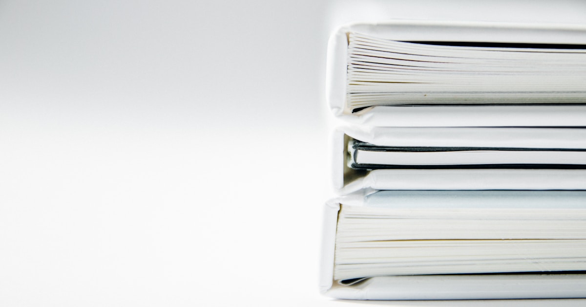 Stacks of paper folders and documents, representing adding a folder of files to Claude